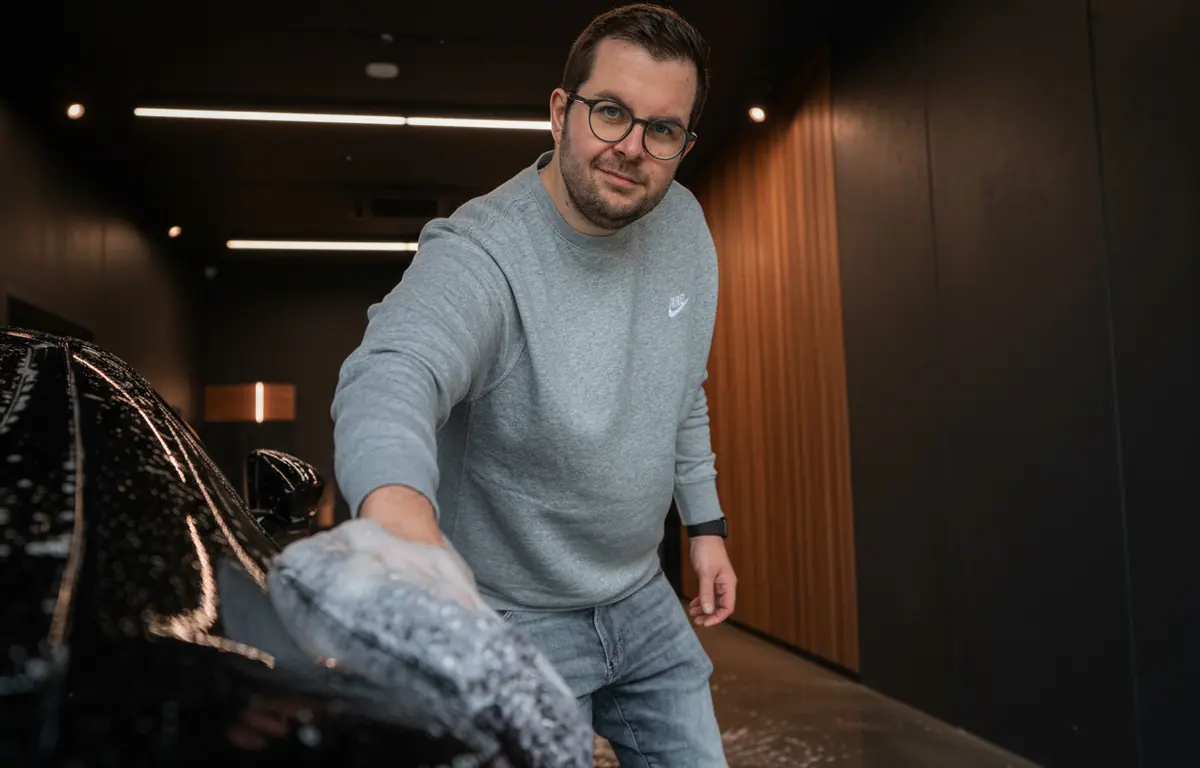 Marvin Mieth wäscht ein schwarzes Auto im Glossboss-Studio